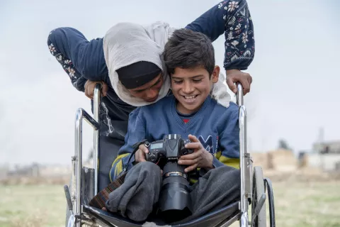 Azzam, 12, with his sister Sidra 14, holds the camera of a photographer for the first time in his life, on 21 February 2022.