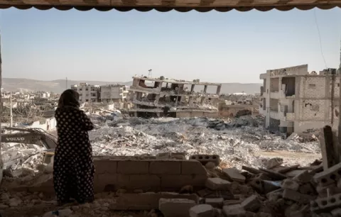 A woman looks over a scene of destruction following the earthquakes, Jinderis, Syria. © UNFPA/Karam Al-Masri
