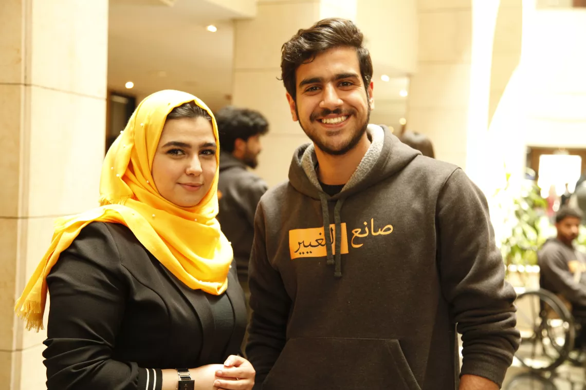 A young woman and a young man standing and smiling