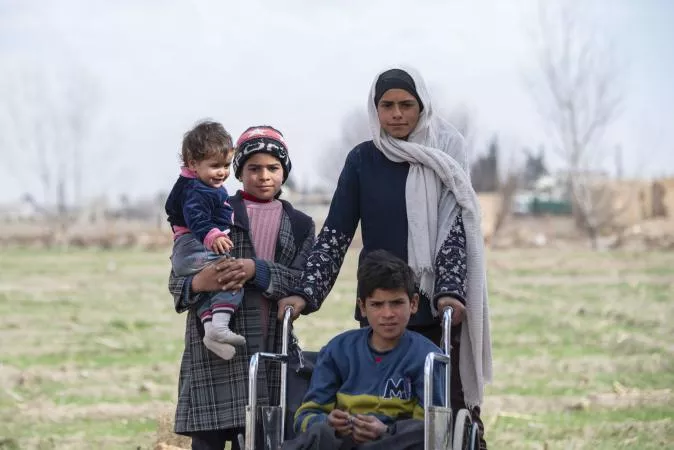Picture of brothers and sisters, with an adolescent girl, a girl holding a boy in her arms and a boy with disabilities sitting in a wheelchair